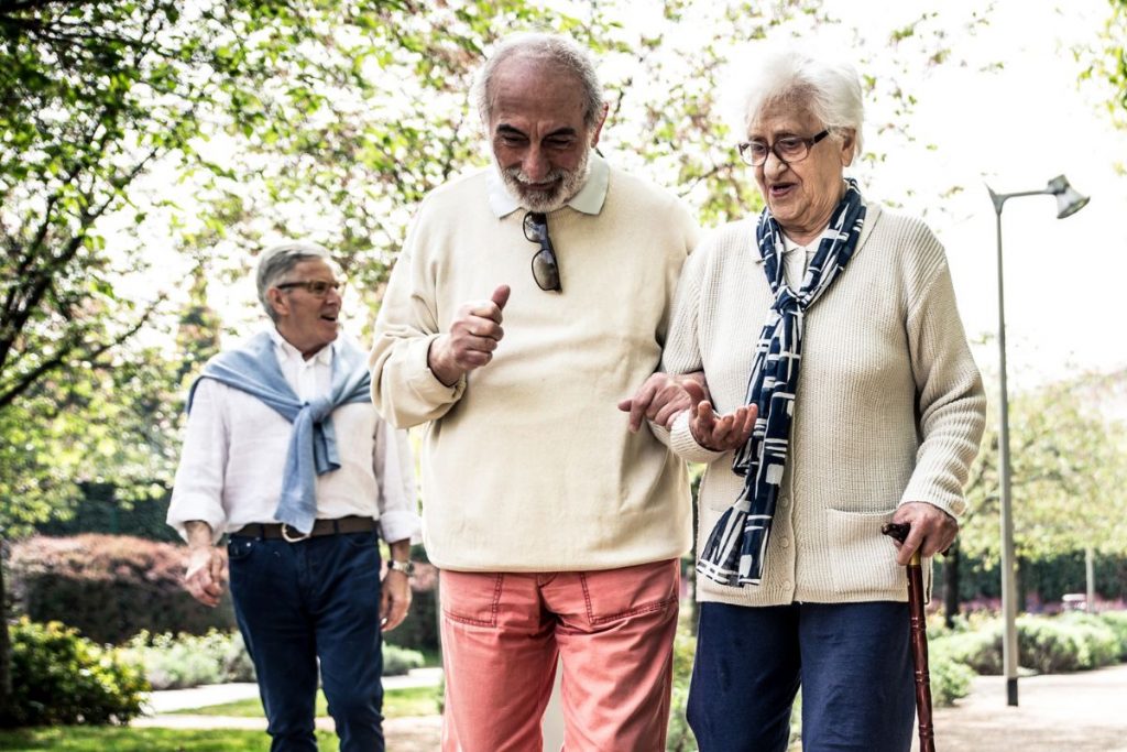 Personas mayores de la mano caminando